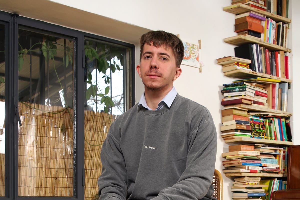 Federico Nejrotti seduto davanti a una libreria